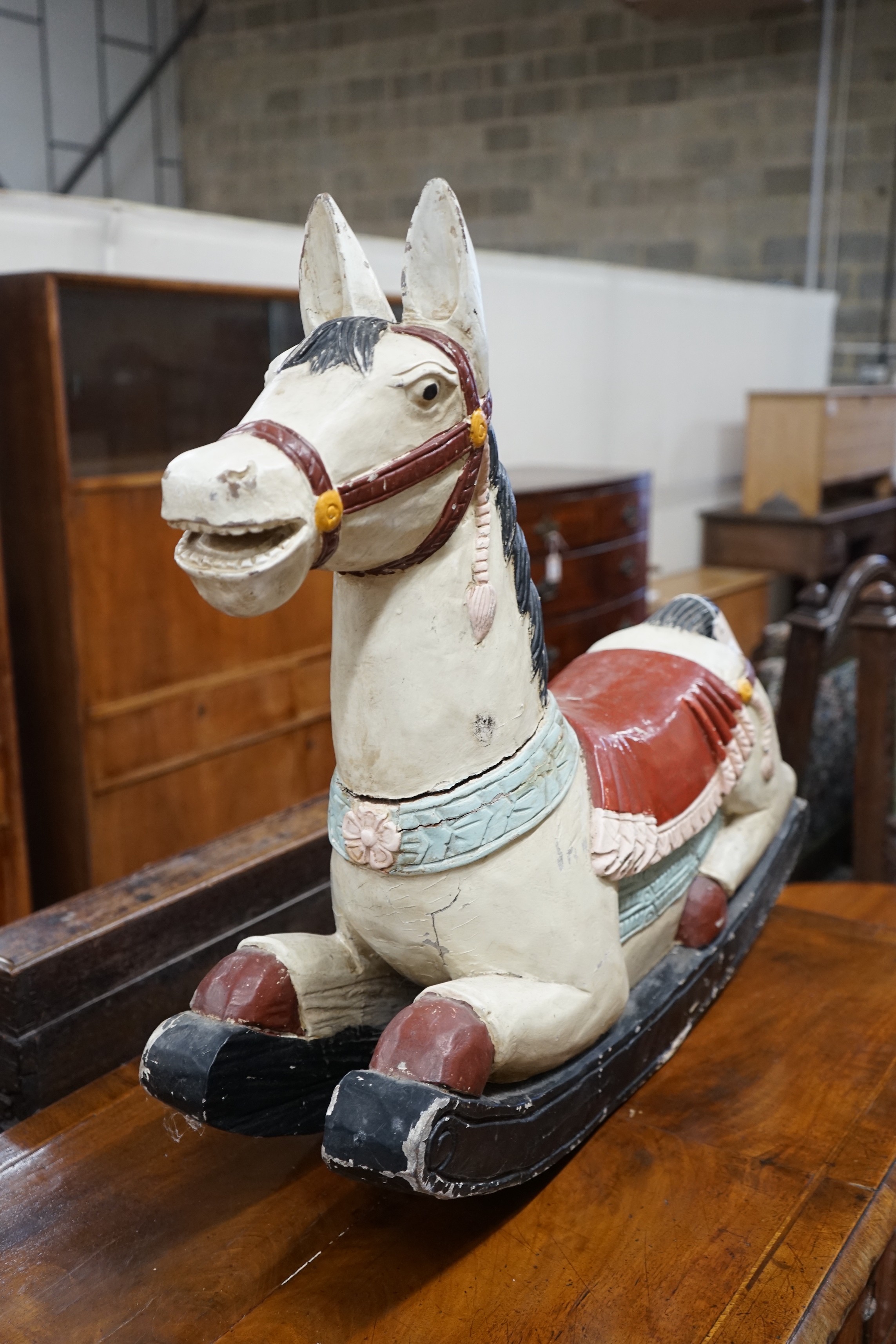 An Indonesian painted carved wood rocking horse, length 75cm, height 66cm